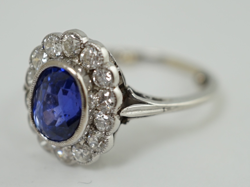 A mid 20th century white gold and millegrain set sapphire and diamond oval cluster ring